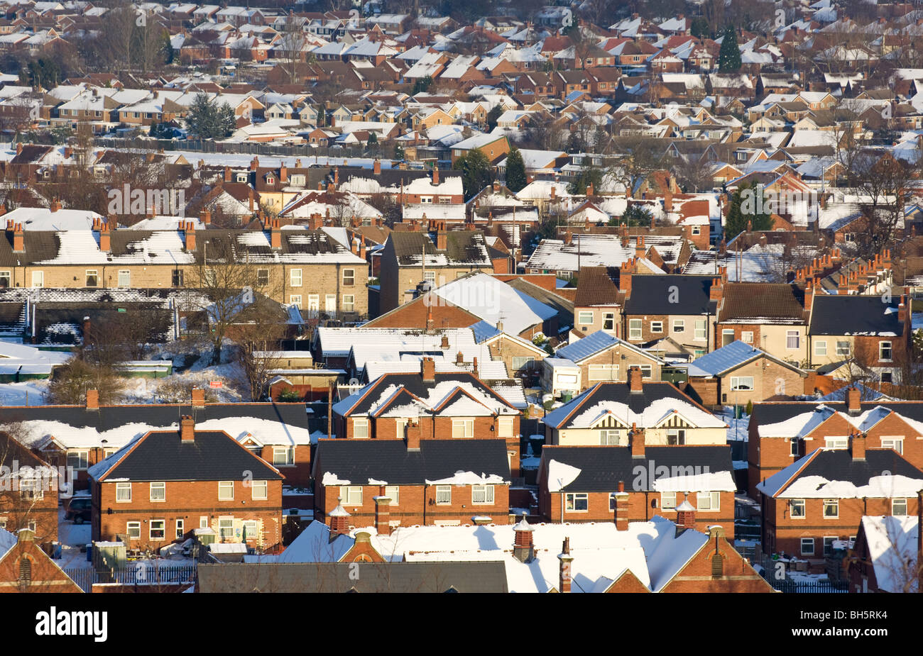 Housing with poor loft insulation. Heat loss soon melting the layer of snow. Stock Photo