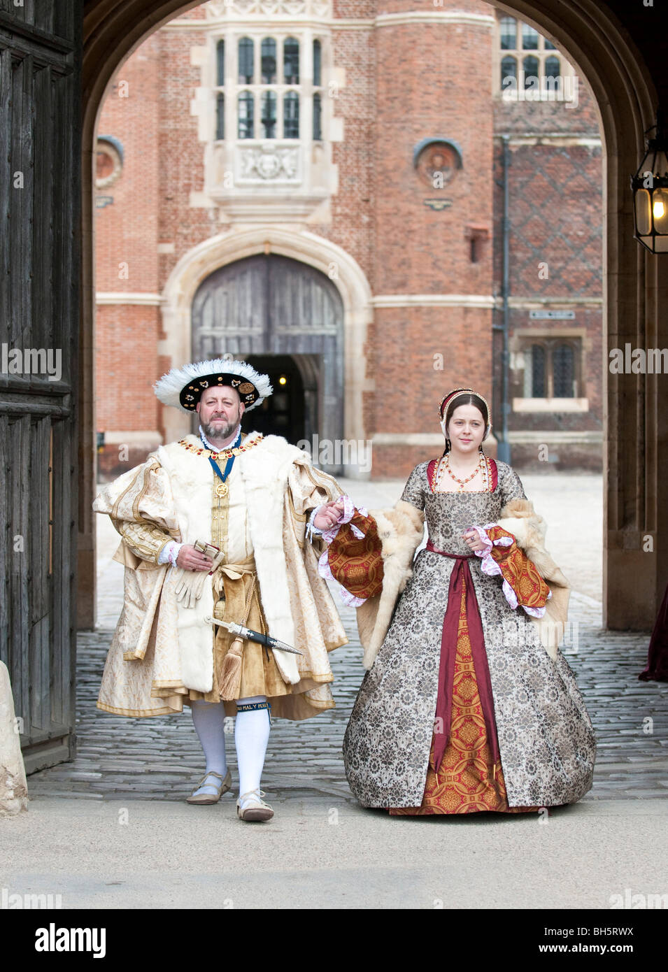 Two actors in Henry VIII and Ann Boleyn costumes posing outside the gate at Hampton Court Palace Stock Photo
