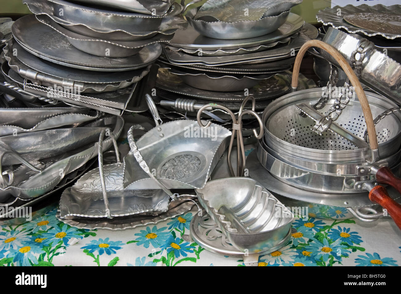 This photo shows stacks of tarnished, antique silver platters and other kitchenware. Stock Photo