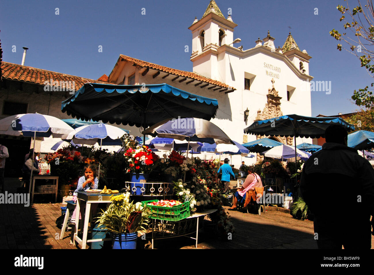 Ecuador, Cuenca, view of a flower market under the shade of sun umbrellas on the place in front of the white Monastery of El Car Stock Photo