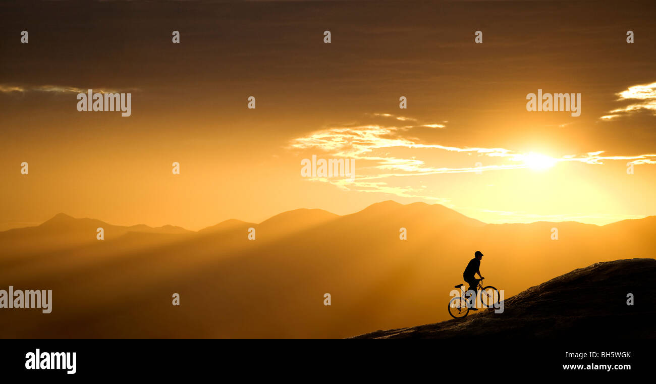 Mountain biker rides up a hill at sunset. This one is in Arizona, just west of Tucson. Stock Photo