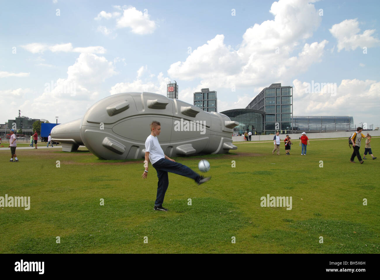 Germany. Youth kicking ball by giant football boot during World Cup 2006 in Berlin Stock Photo