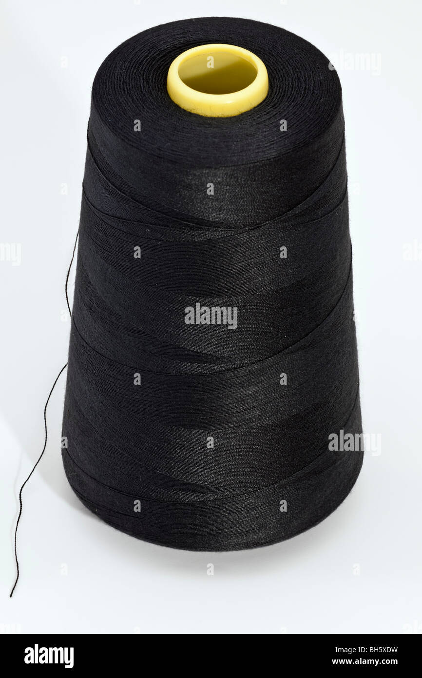 5000 yards of 120 spun black polyester thread on a large loom spool Stock Photo
