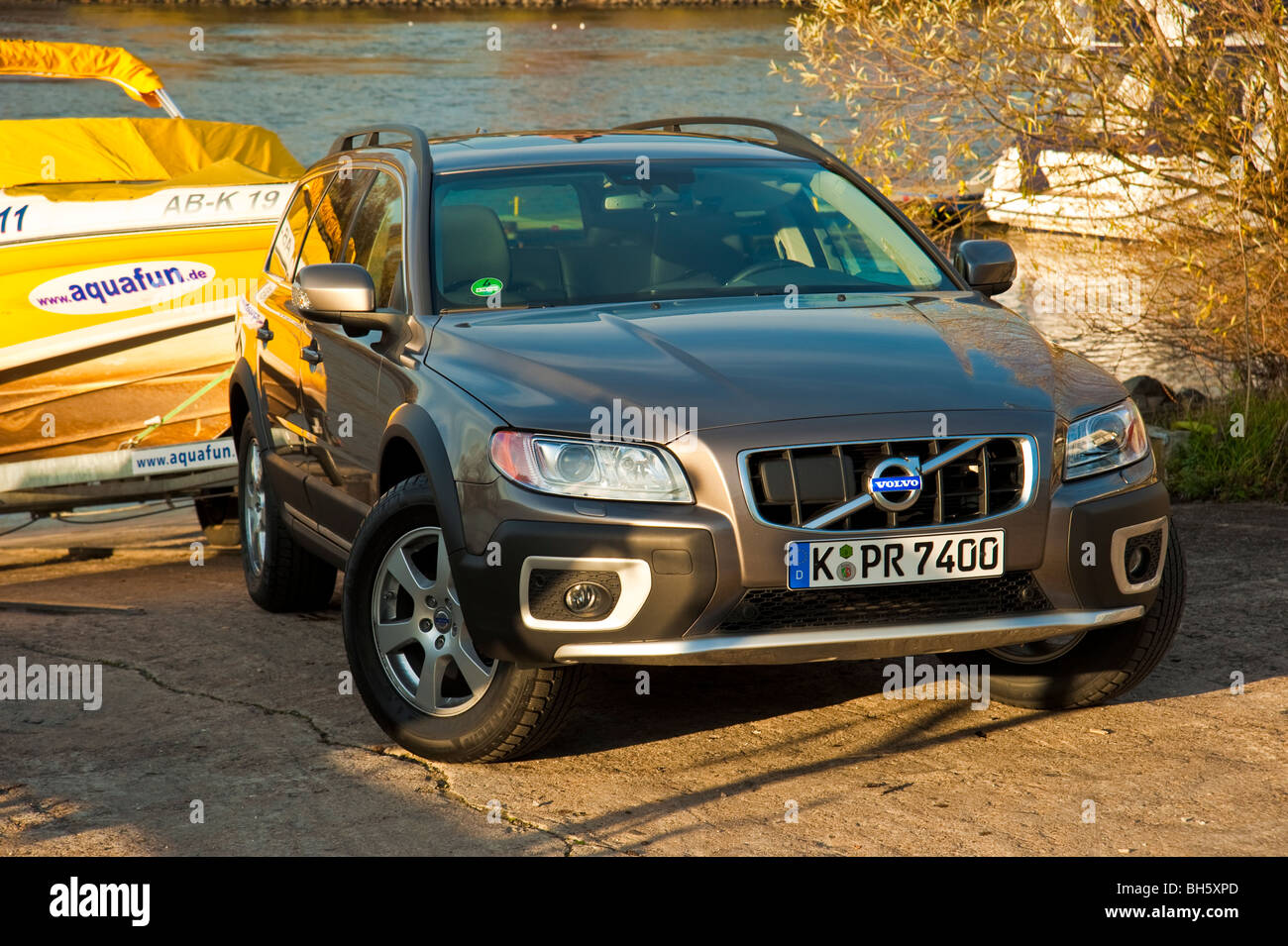 Volvo XC 70 four wheel drive station wagon slipping a yellow power boat at Rhine river Stock Photo