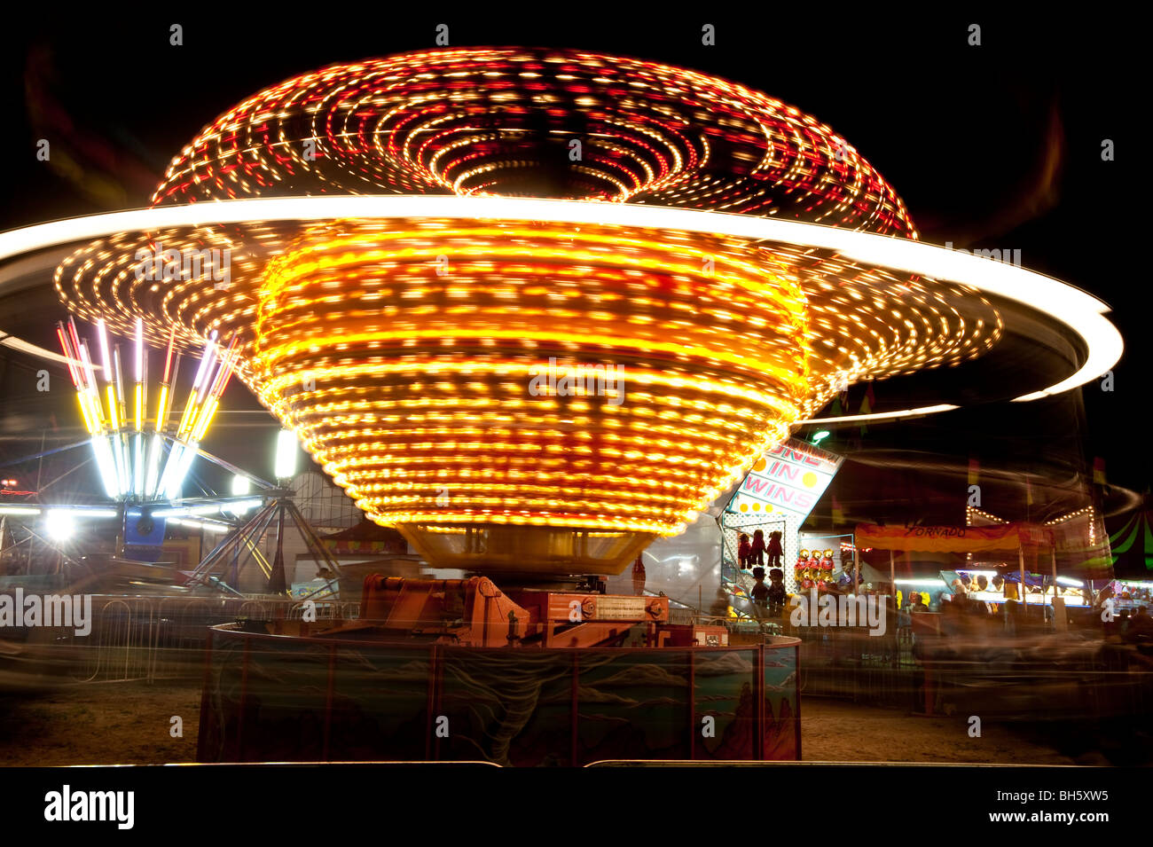 Swirling lights of carnival rides at night. Stock Photo