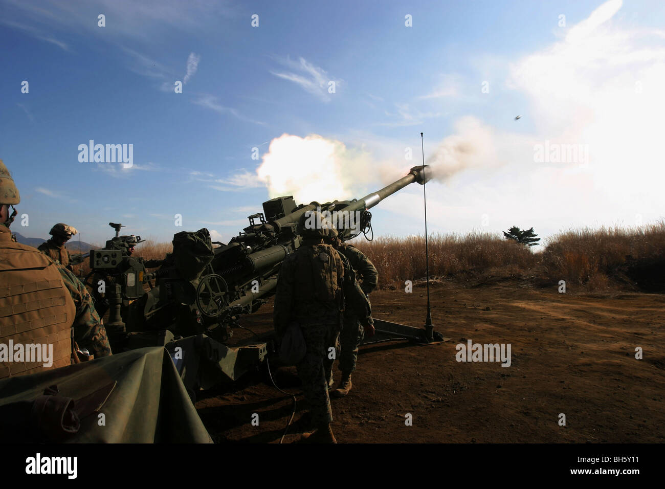 Artillerymen fire a 155mm round out of an M777 lightweight howitzer. Stock Photo