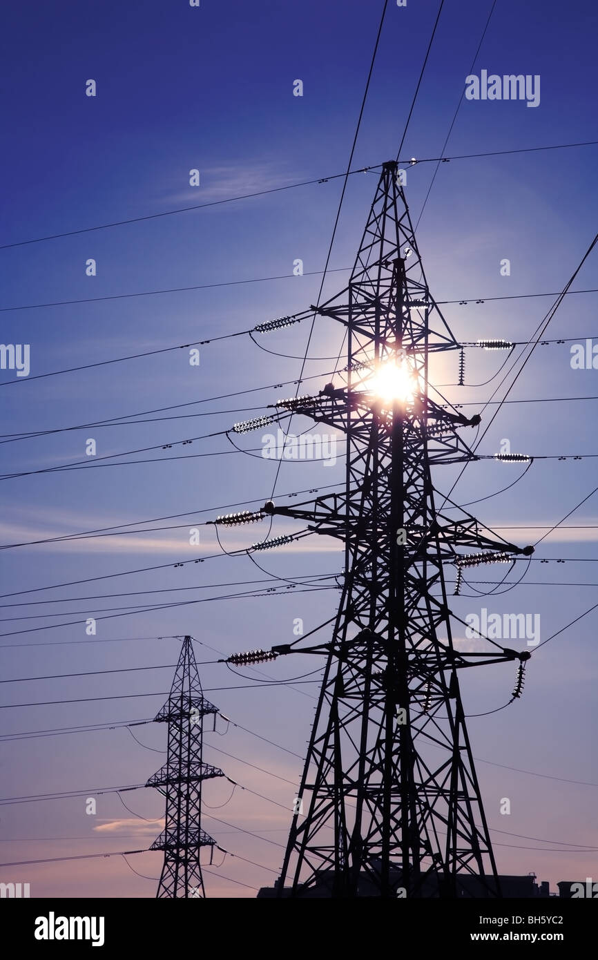 High voltage tower against the sun. Stock Photo