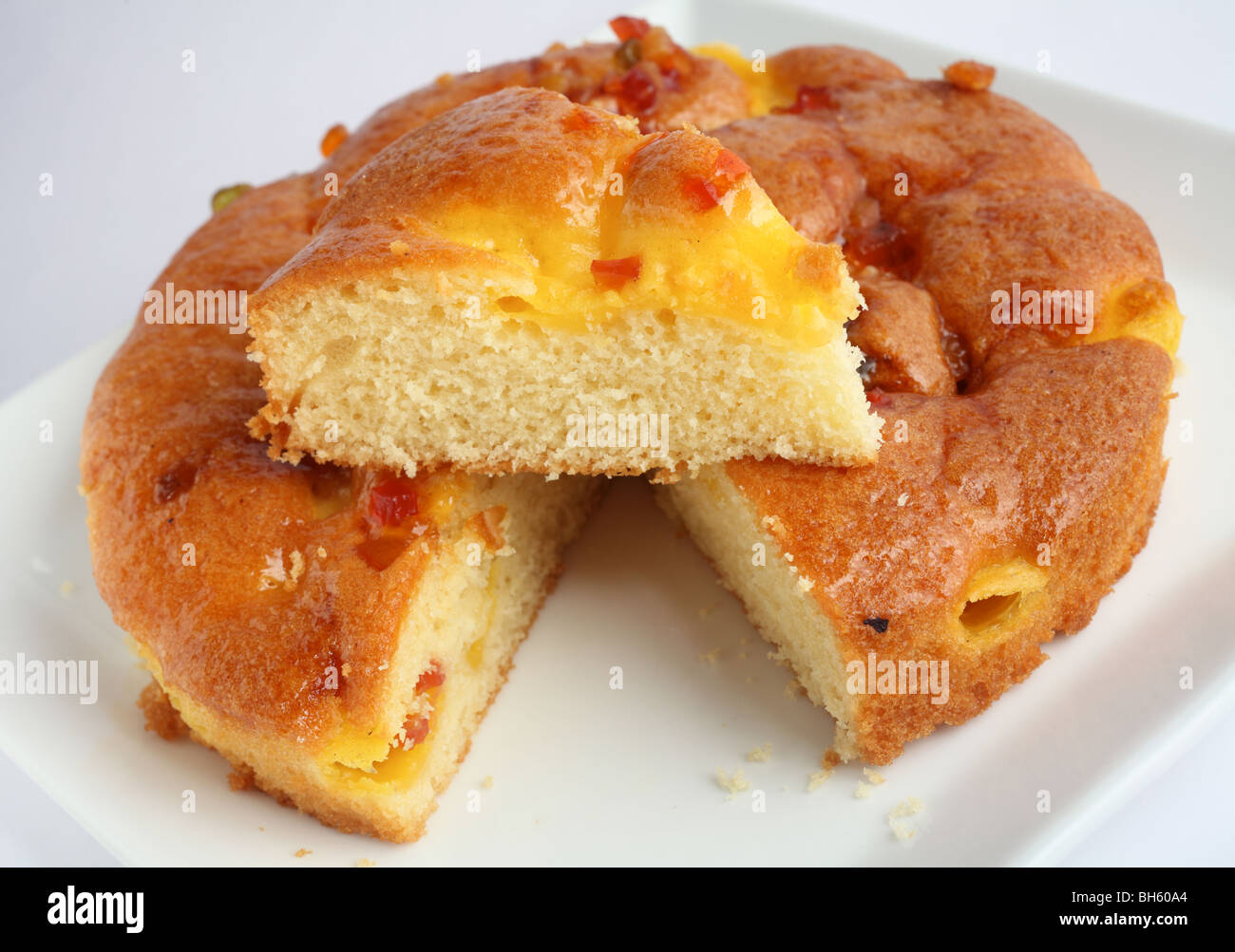 An italian style sponge cake with a wedge cut out and placed on top to show the texture Stock Photo