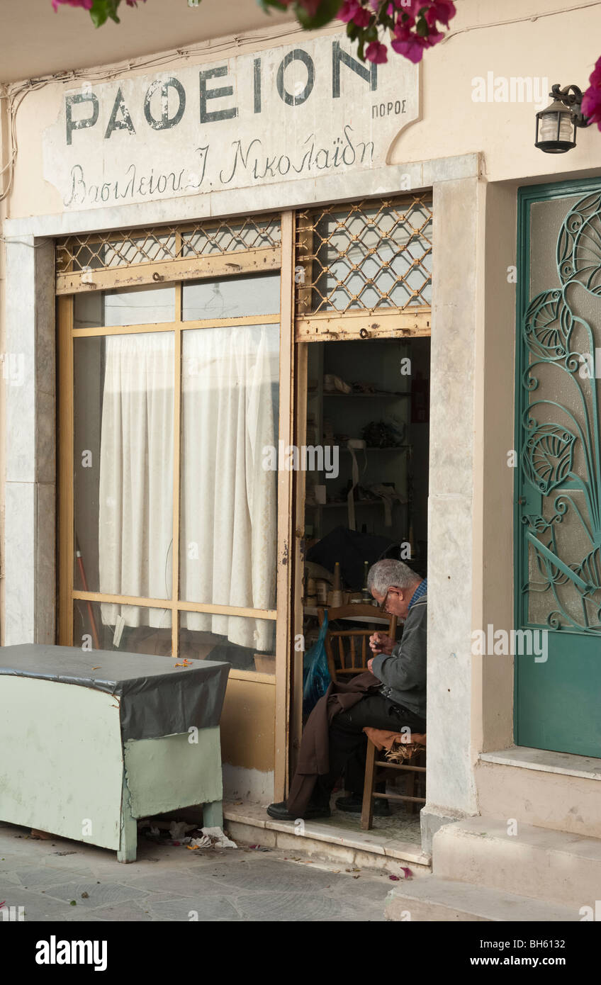 Old tailor at work sewing with needle and thread in Poros Town, Poros Island, Greece Stock Photo