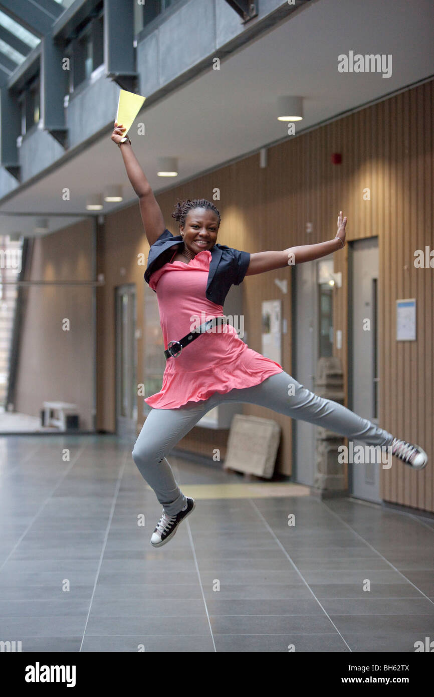 Happy teenage girl jumping for joy with her certificate Stock Photo