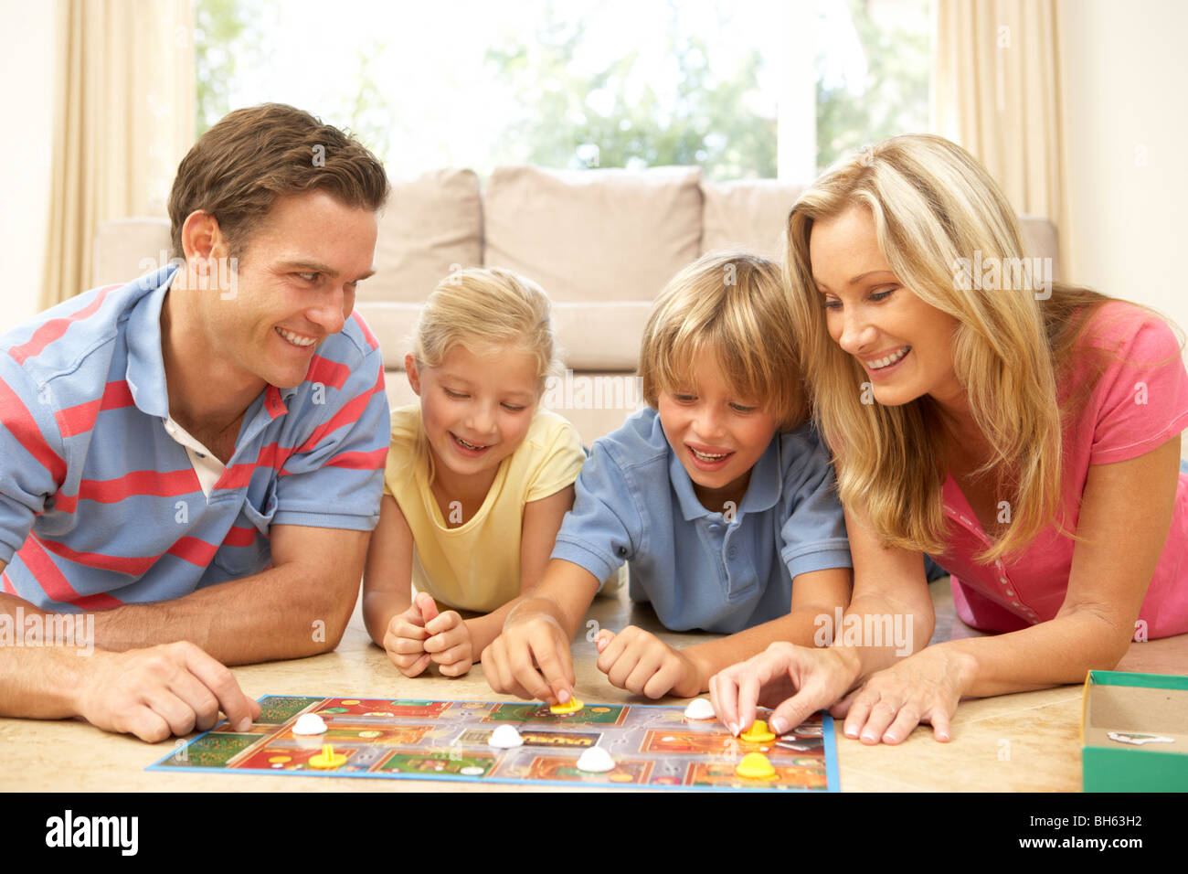 Family Playing Board Game At Home Stock Photo