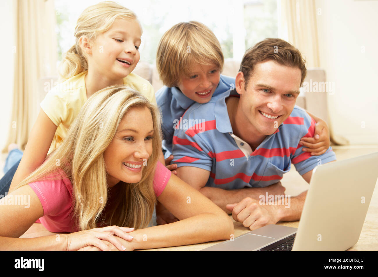 Family Using Laptop At Home Together Stock Photo - Alamy