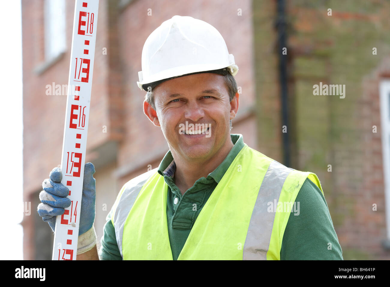 Construction Worker Holding Measure Stock Photo