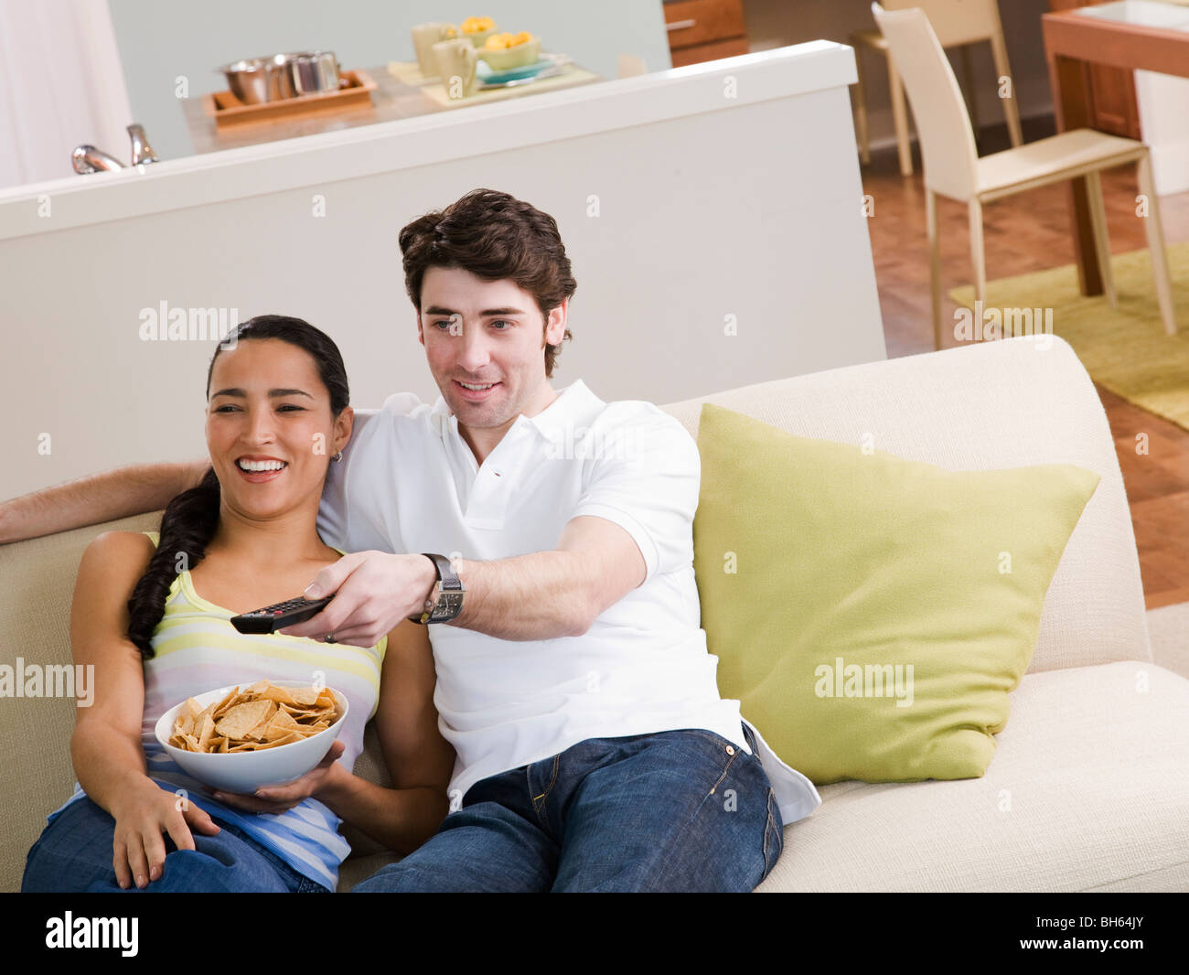 Couple sitting on couch watching TV Stock Photo Alamy
