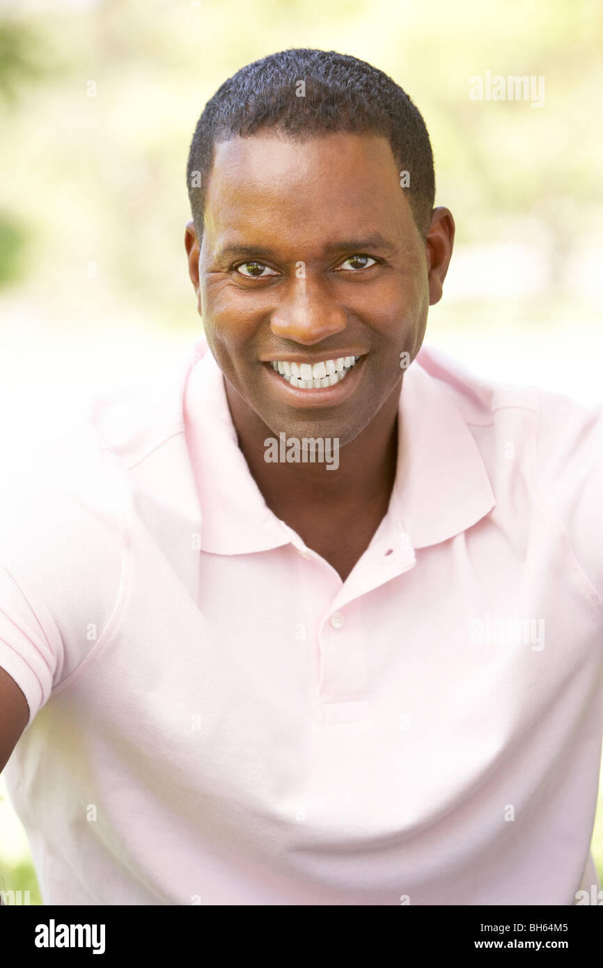 Portrait Of Young Man Sitting In Park Stock Photo