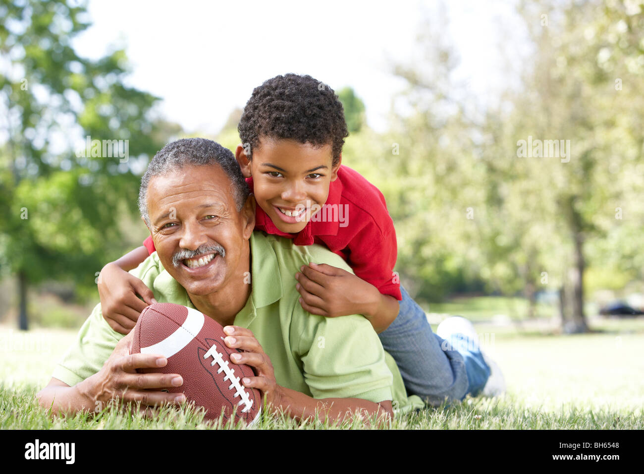 Grandfather With Grandson In Park With American Football Stock Photo Alamy