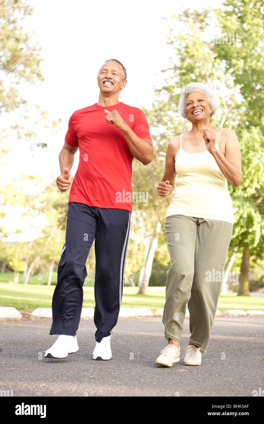 Senior Couple Jogging In Park Stock Photo