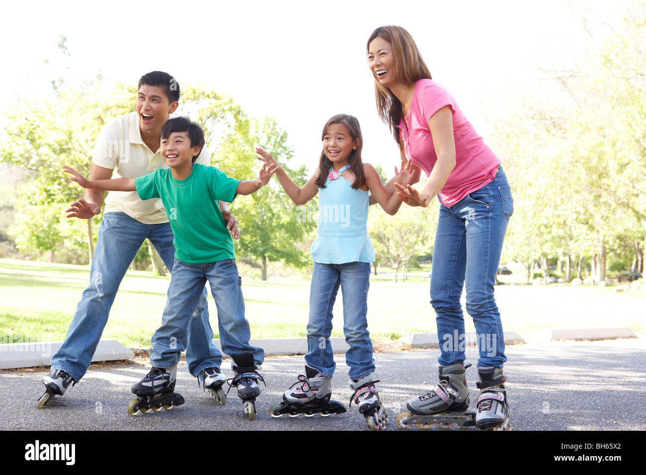 Family Putting On In Line Skates In Park Stock Photo