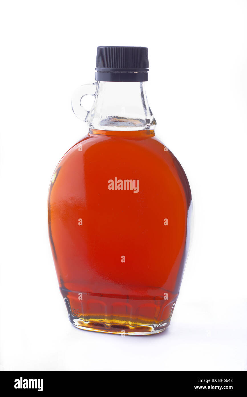 A bottle of maple syrup sits on a white background Stock Photo