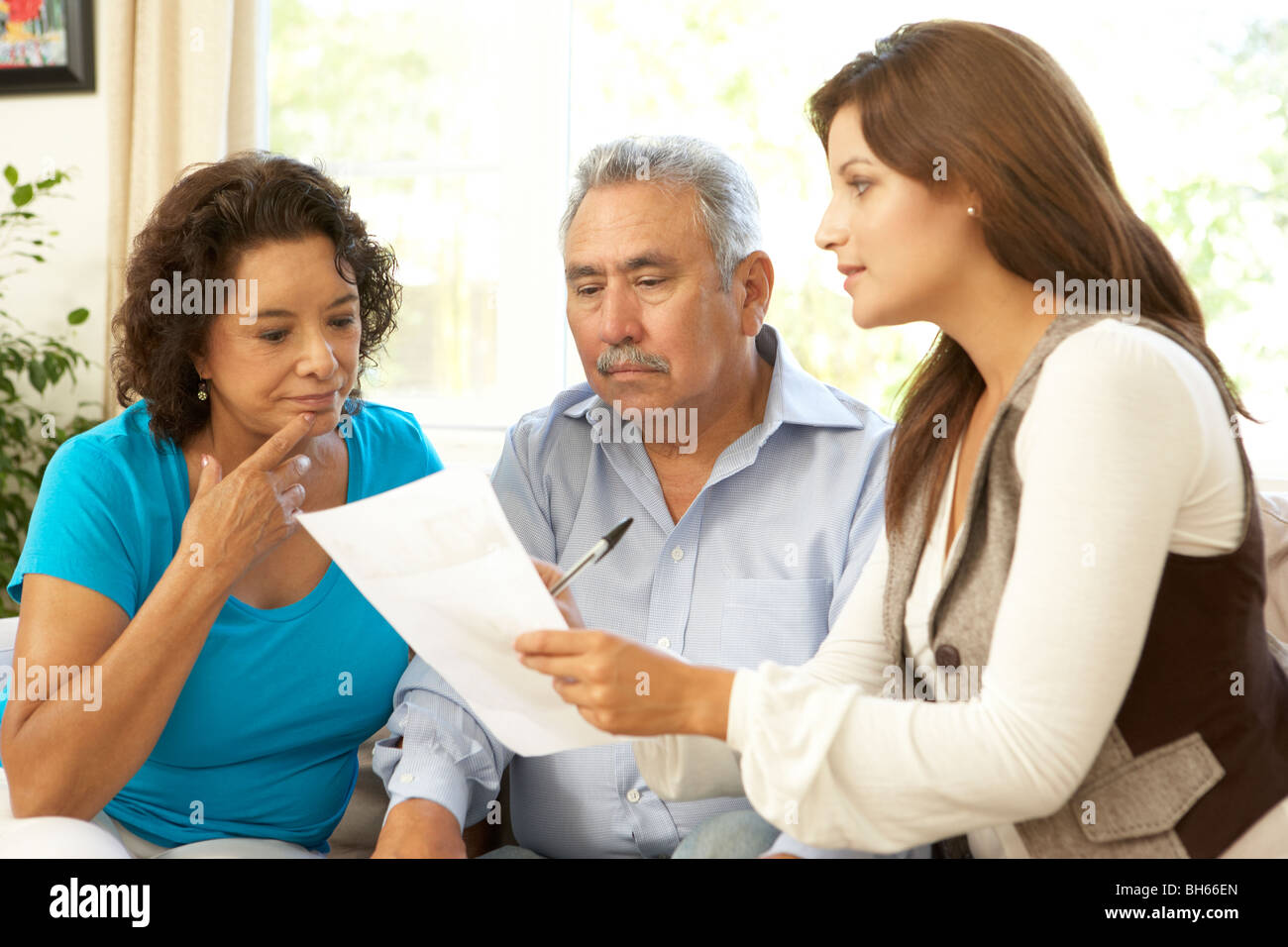 Senior Couple With Financial Advisor At Home Stock Photo