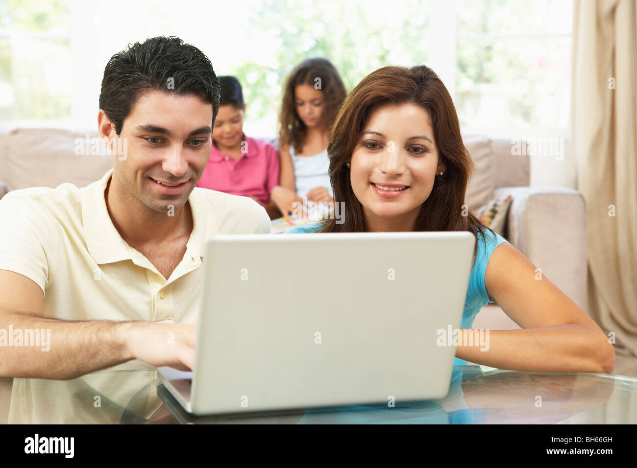 Parents Using Laptop At Home Stock Photo Alamy