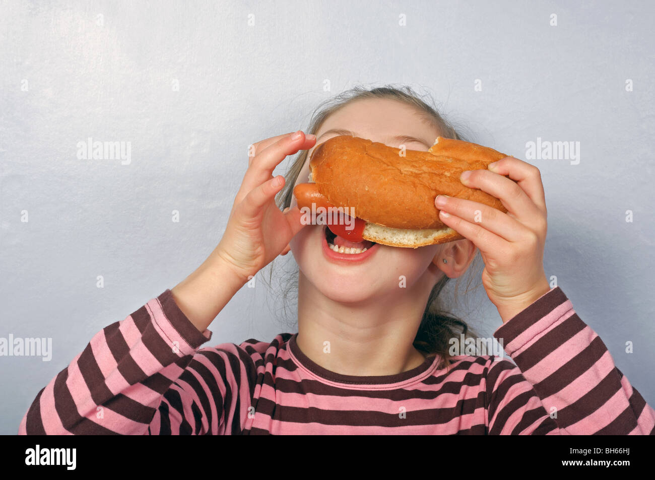 Young girl eating a hot-dog Stock Photo