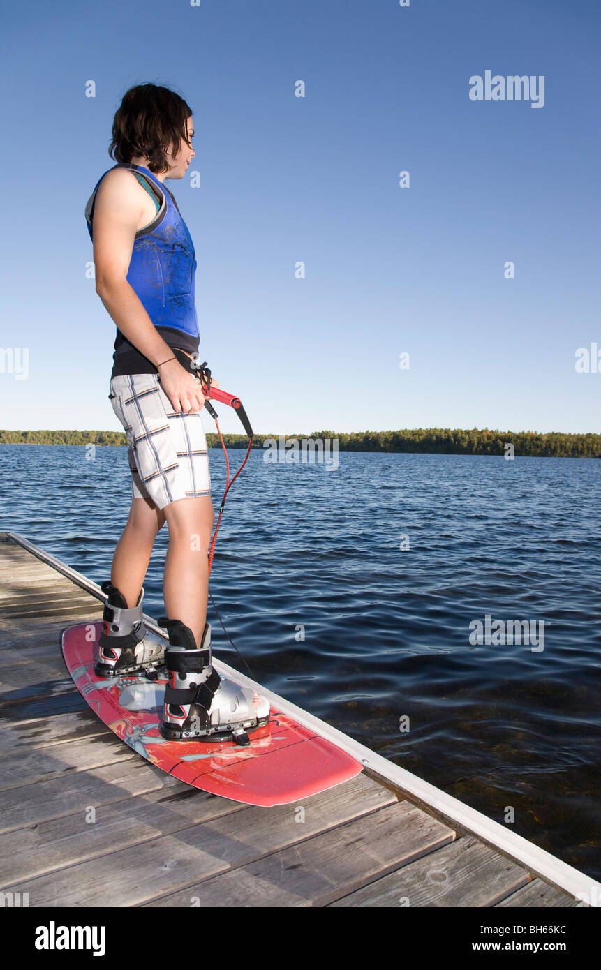 Woman standing on dock with wakeboard Stock Photo