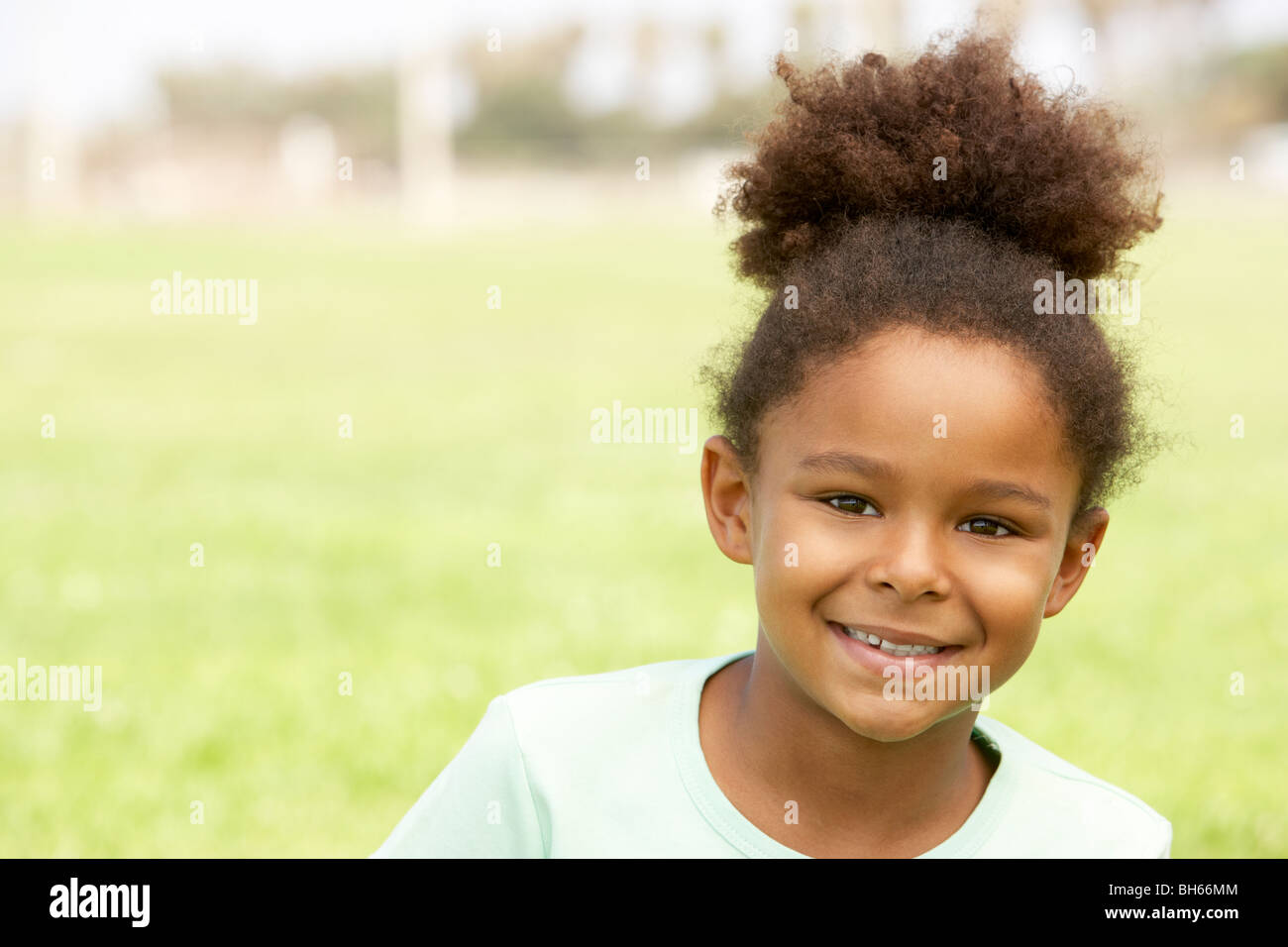 Portrait Of Young Girl Sitting In Park Stock Photo - Alamy