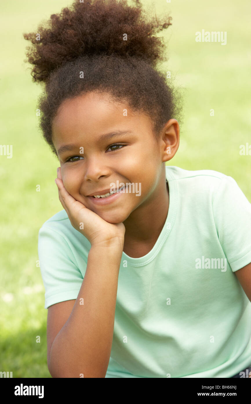Portrait Of Young Girl Sitting In Park Stock Photo - Alamy