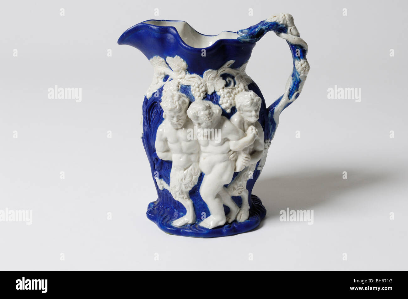 An antique 19th C. English stoneware relief moulded jug with  Bacchanalian ornament. Figures: infant Bacchus, old Silenus etc. Stock Photo