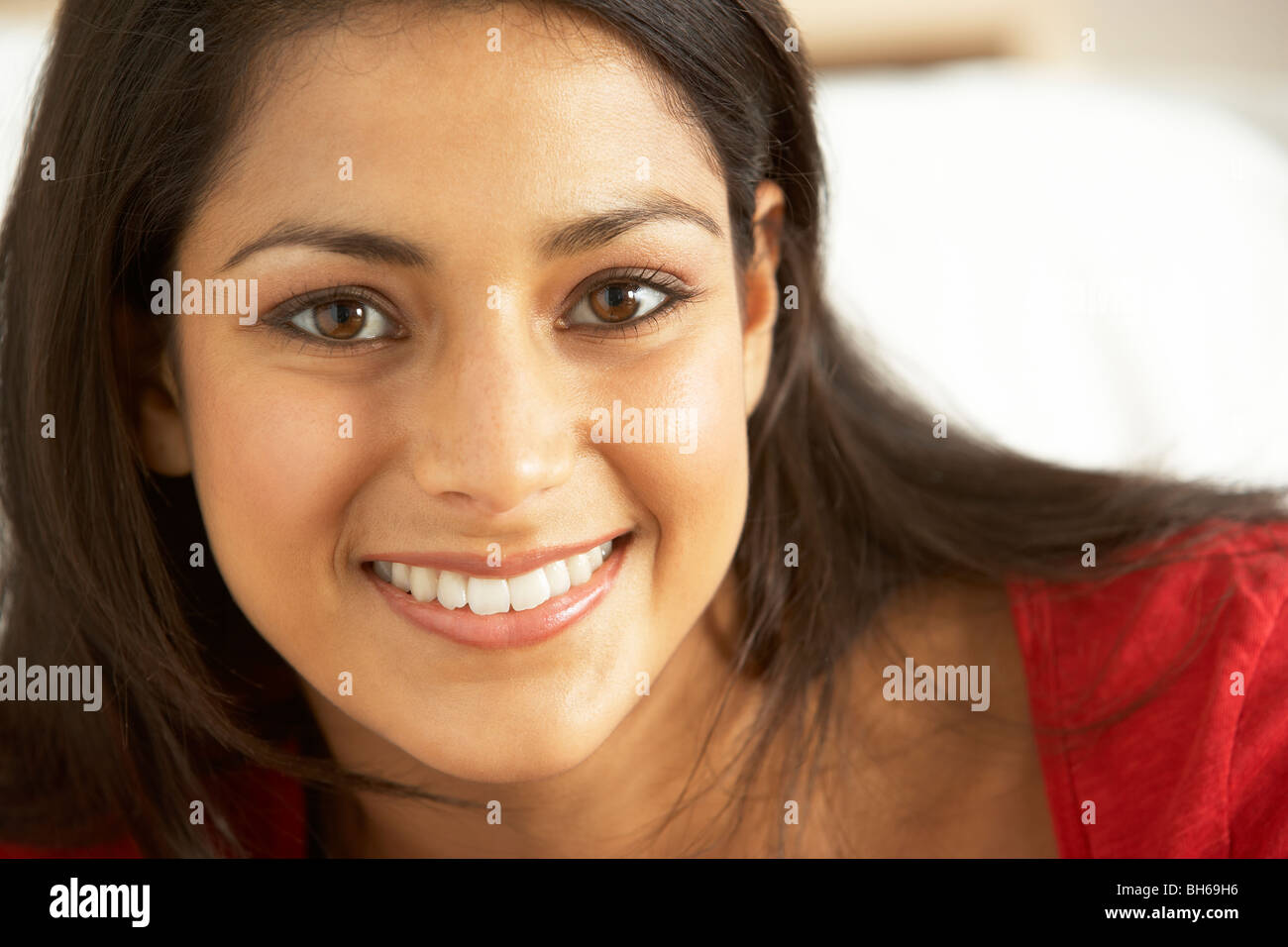 Portrait of young woman sitting on sofa Stock Photo - Alamy