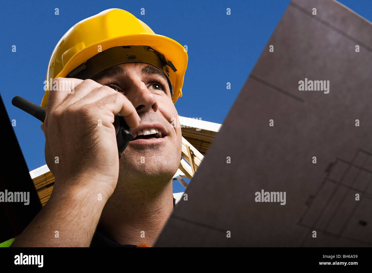 Construction worker holding plans Stock Photo