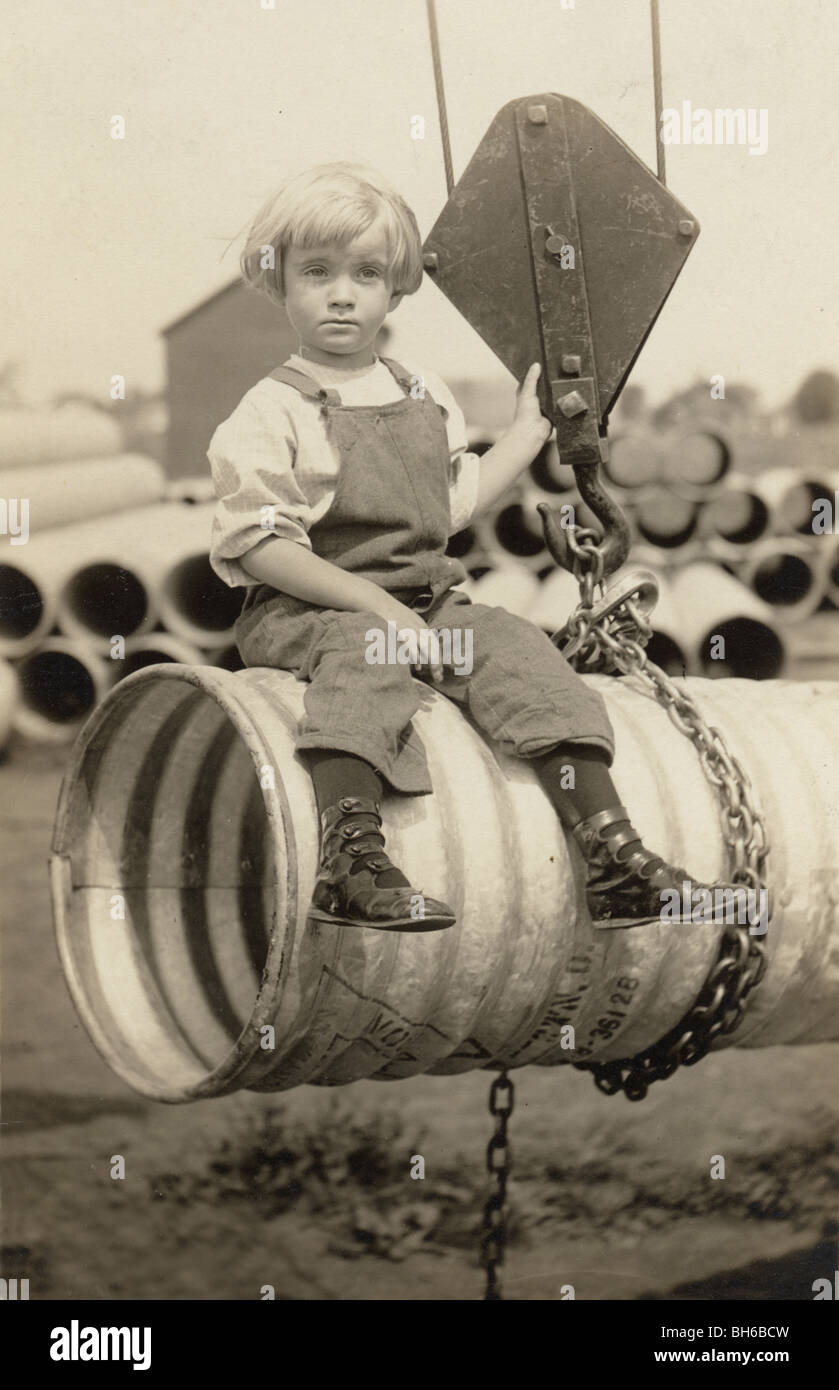 Little Girl Sitting on Suspended Drain Pipe Stock Photo