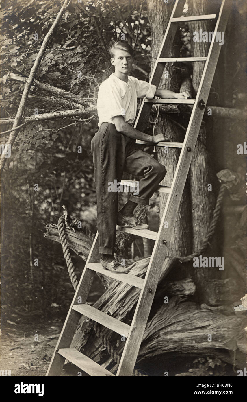 Young Man Climbing Tall Ladder Stock Photo Alamy