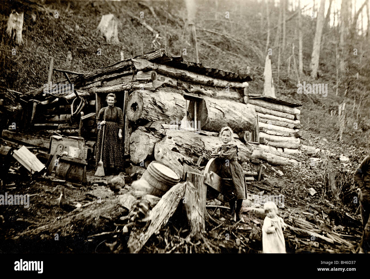Mother & Daughters at Ramshackle Log Cabin Stock Photo