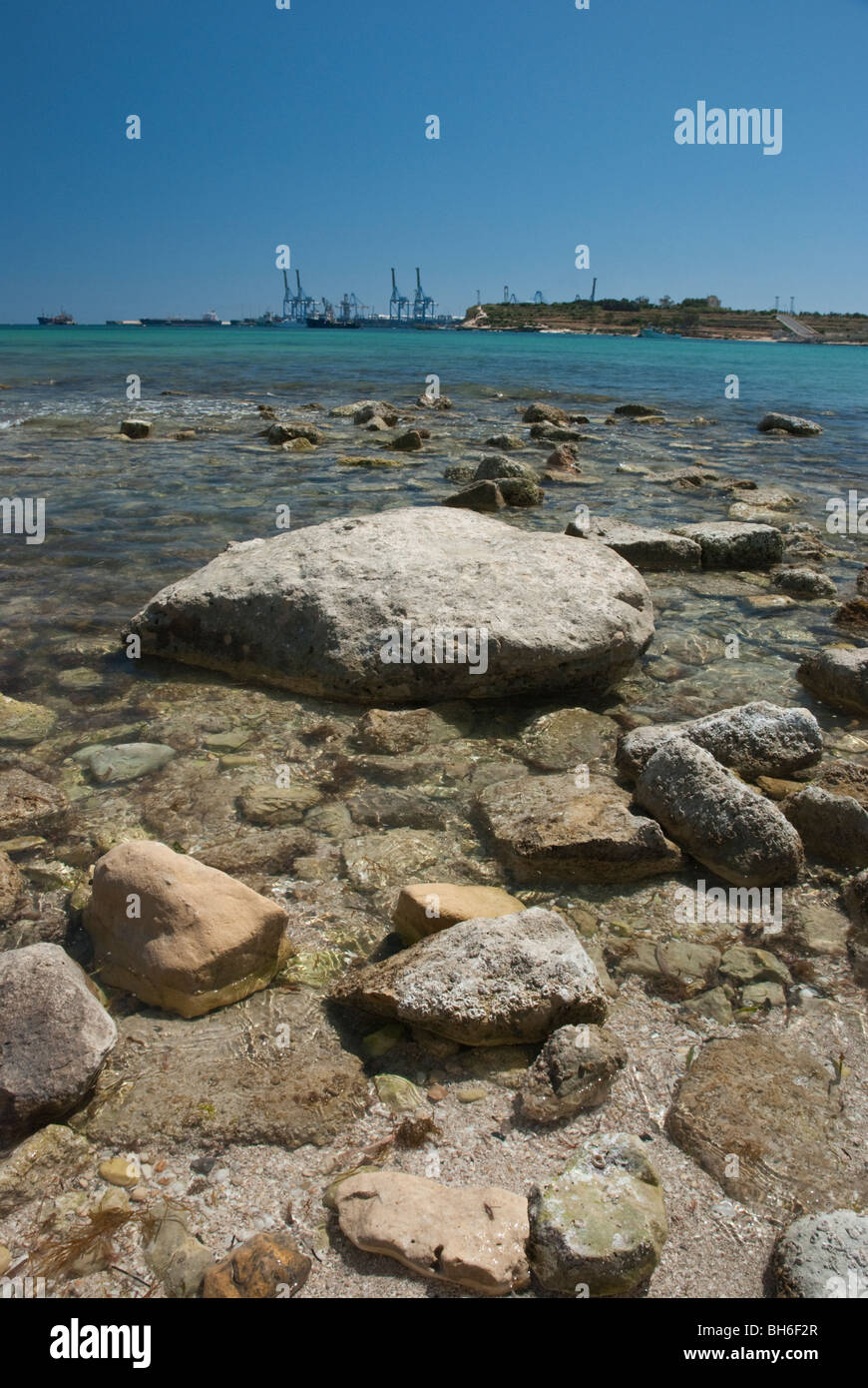 View from Maraslokk of the Mediteranean sea with an oil terminal and cranes on the horizon at Birżebbuġa. Stock Photo