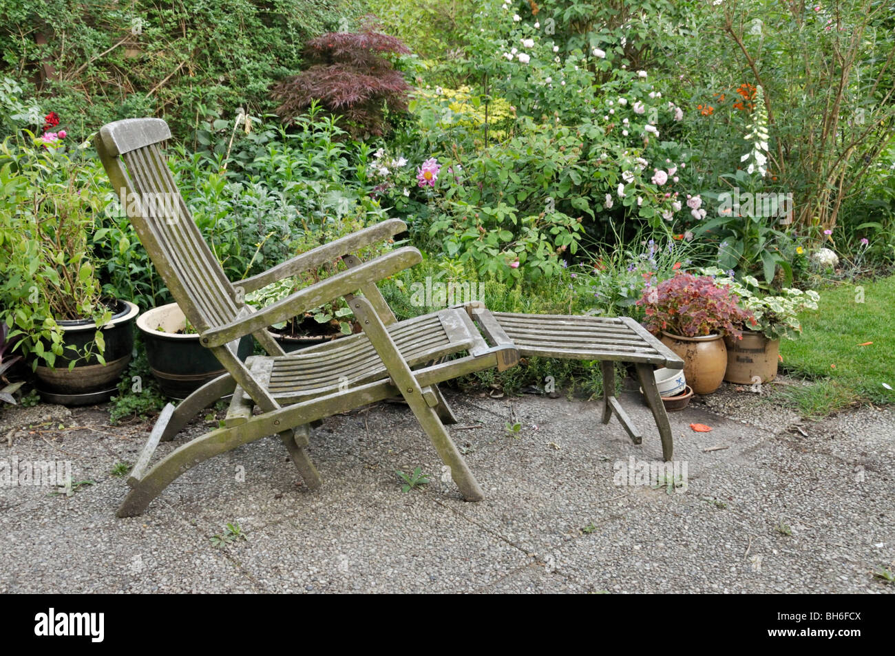 Wooden deck chair with potted plants Stock Photo