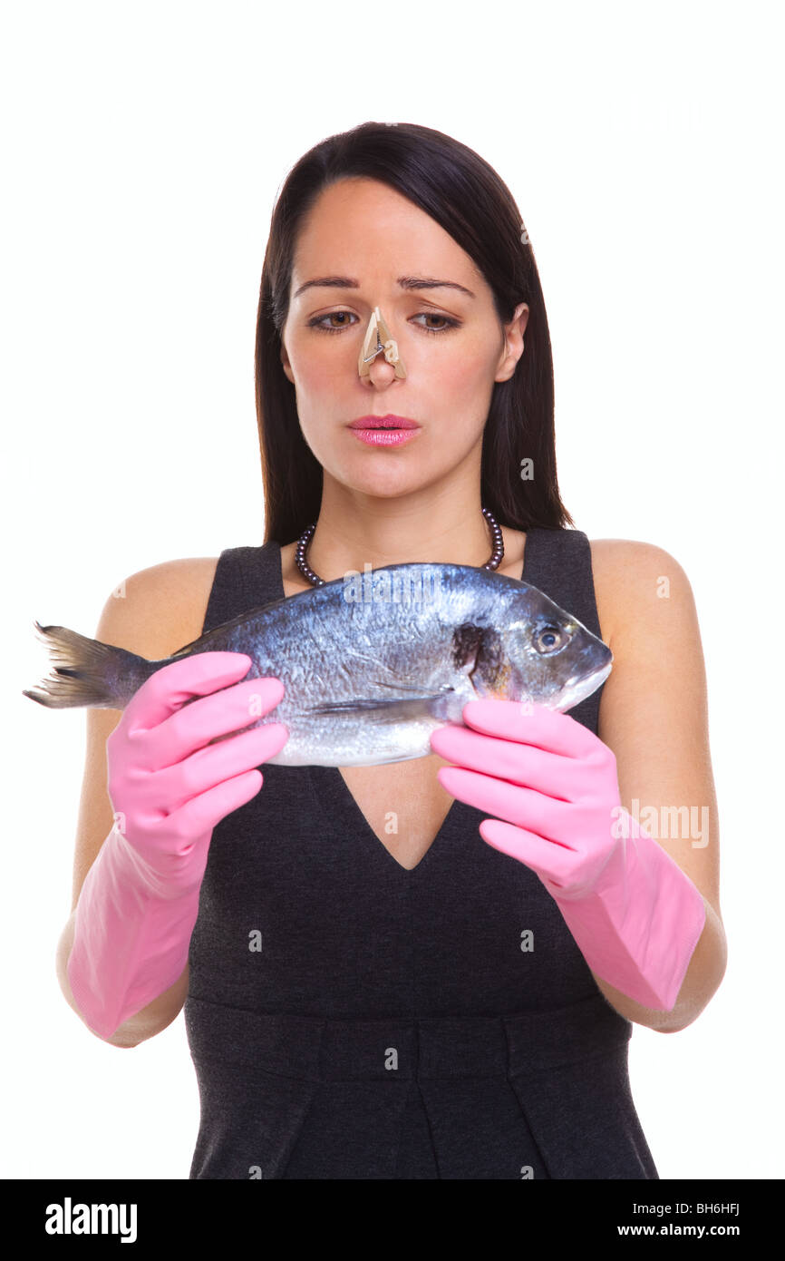 A woman wearing rubber gloves holding a raw fish, isolated on a white