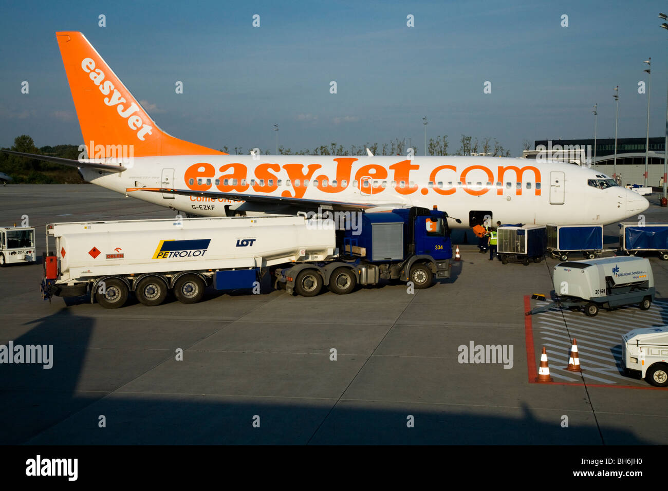 Easyjet aircraft; refueling truck / fuel tanker; and loading passenger baggage; at Krakow’s