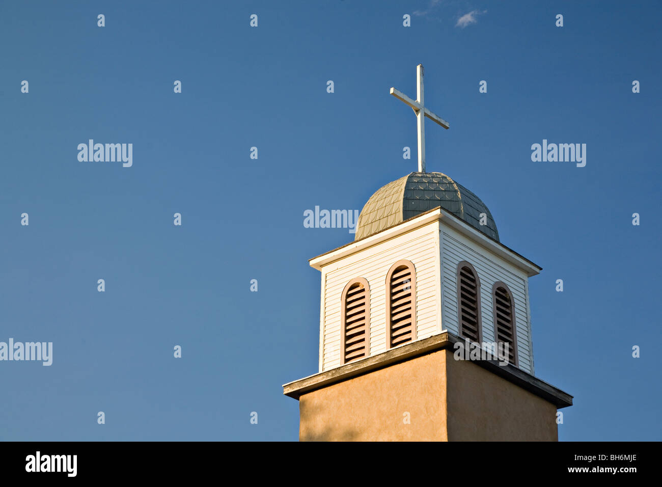Bell tower and cross atop the St. Joseph's Church in Los Cerrillos, New Mexico Stock Photo