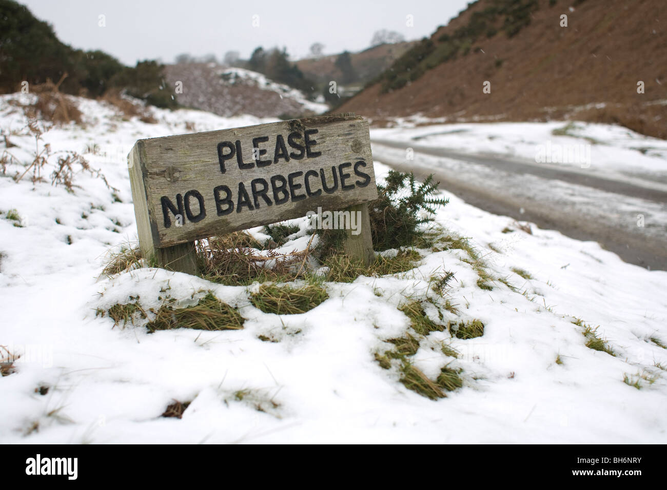 'Please No Barbecues' sign looks amusing in the winter snow. The sign was on the Long Mynd in Shropshire, England, UK. Stock Photo