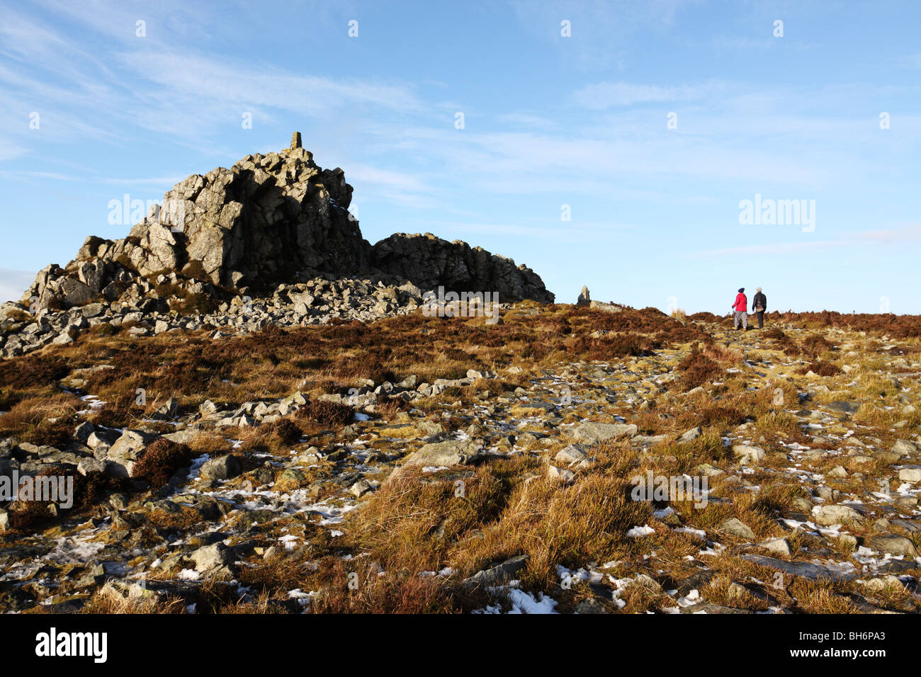 Two walkers approach Manstone Rock, high point along the Stiperstones ridge in the Shropshire Hills AONB Stock Photo