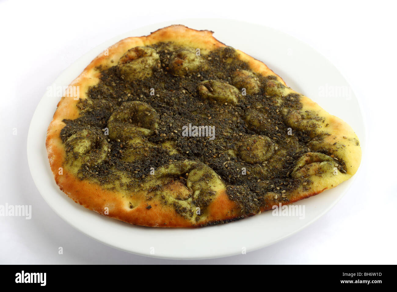 An Arabian manakish bread snack, topped with zattar - a herb mixture based on thyme and sesame seeds. Stock Photo