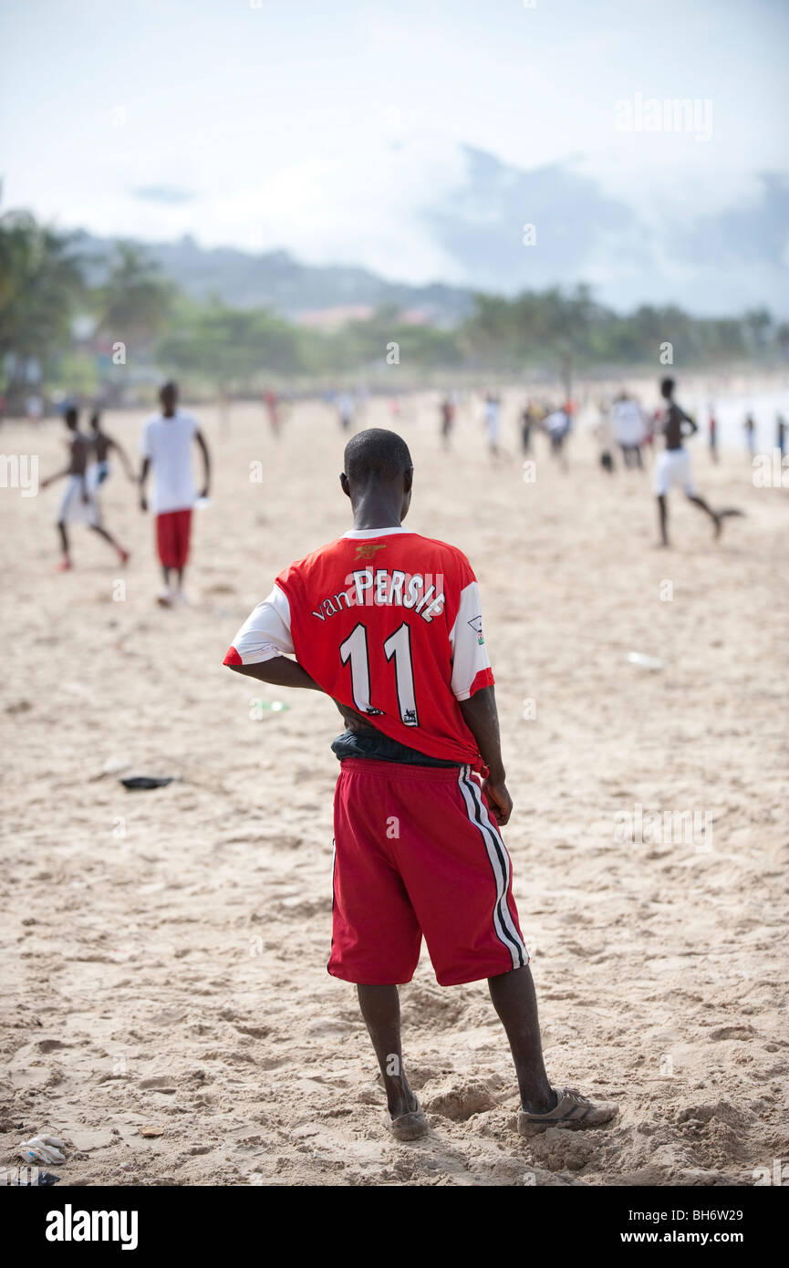 young man on beach in sierra leone in van persie arsenal football shirt Stock Photo