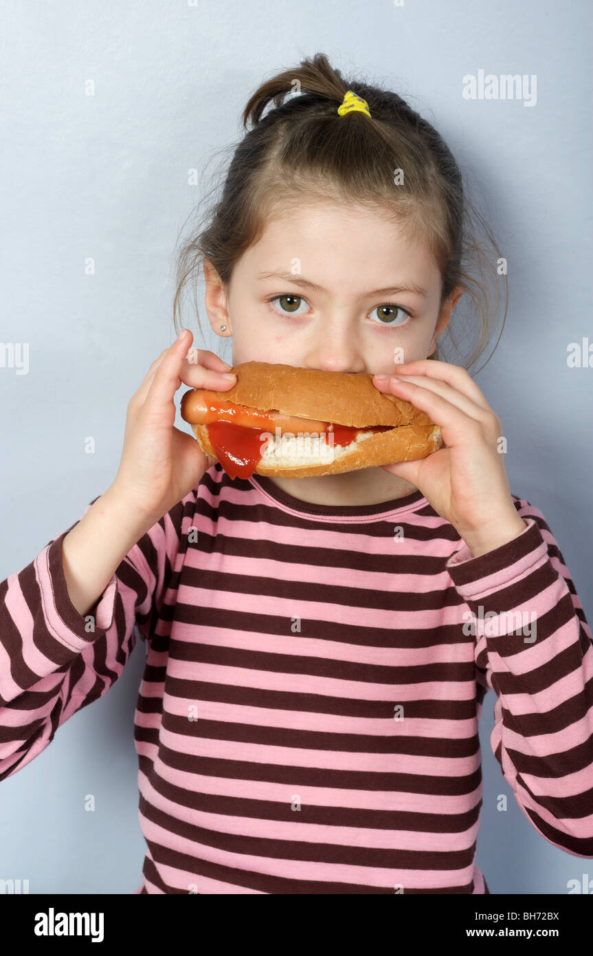 Young girl eating a hot dog Stock Photo