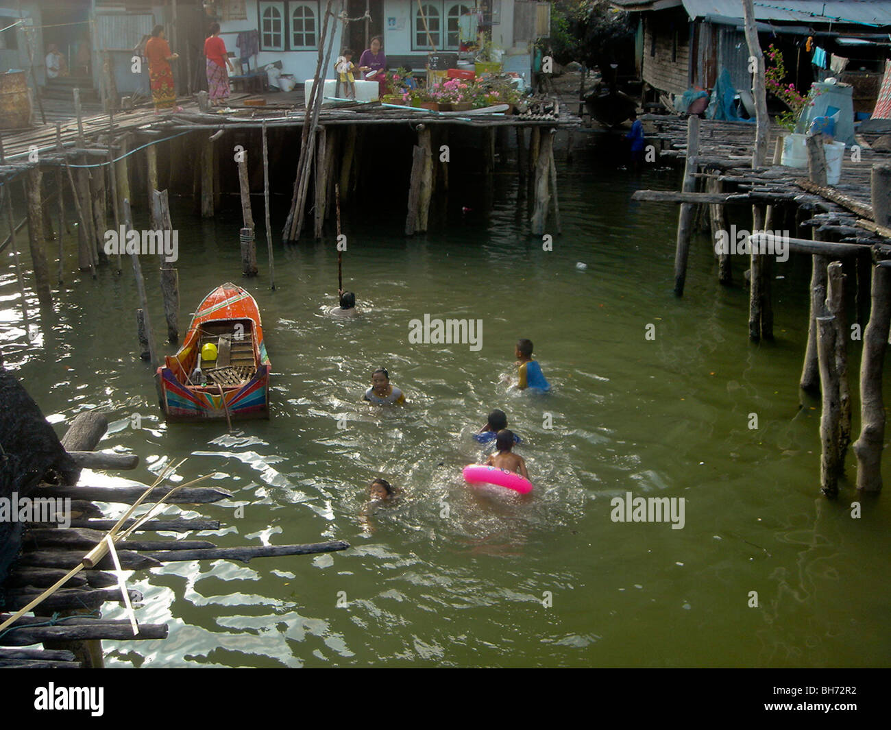 Phuket Beach, Thailand, young male teens swimming off Huts on Stilts Stock Photo