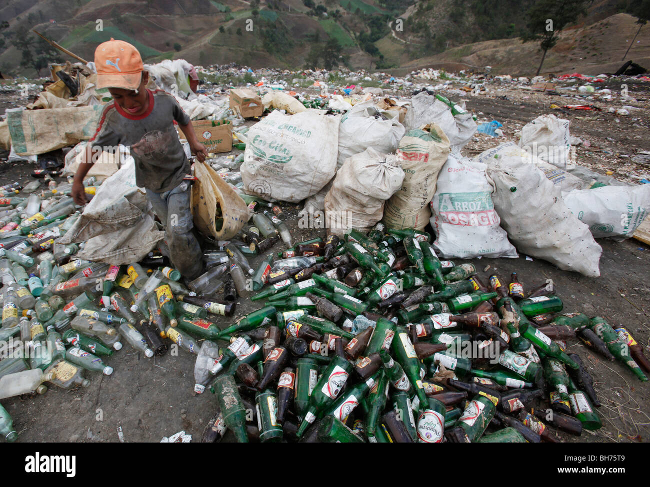 A boy scavenges bottles at a trash disposal area outside of Constanza, Dominican Republic Stock Photo