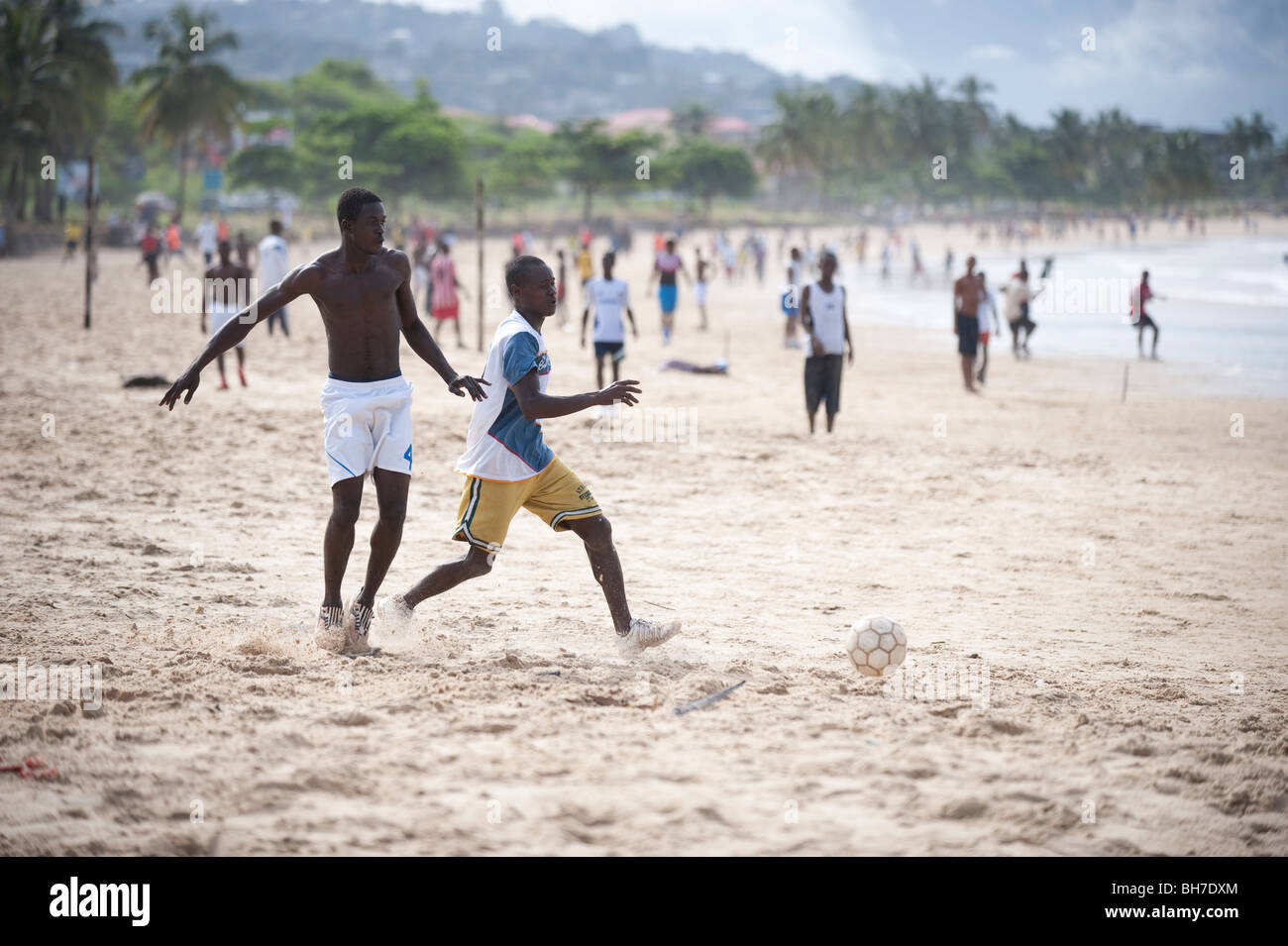 young men playing football on beach in sierra leone Stock Photo