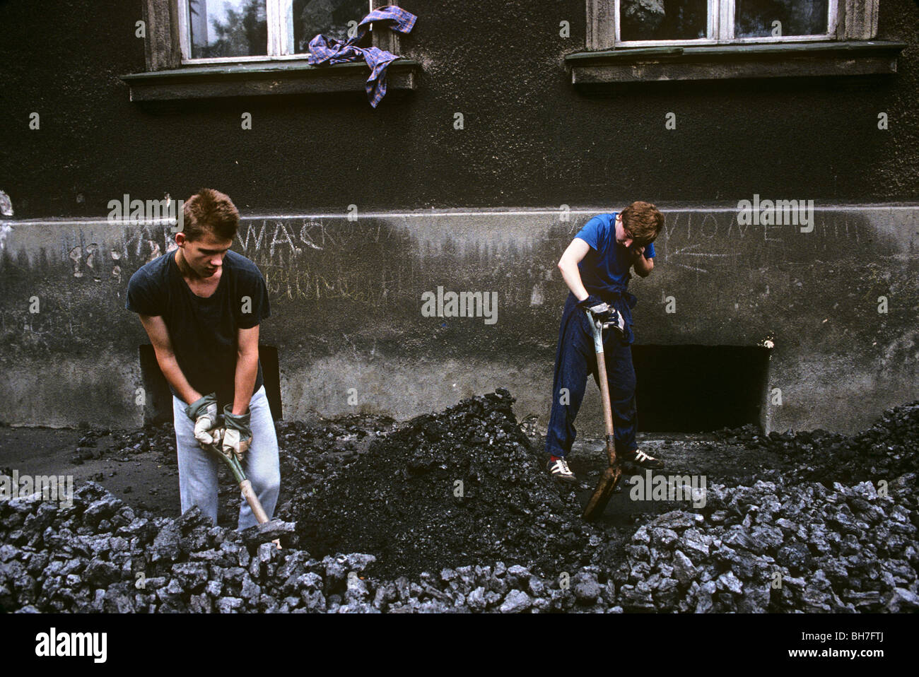 Coal delivery men shovel chunks of brown coal on a street in Aue, a mining town in the Ore Mountains in the former East Germany Stock Photo