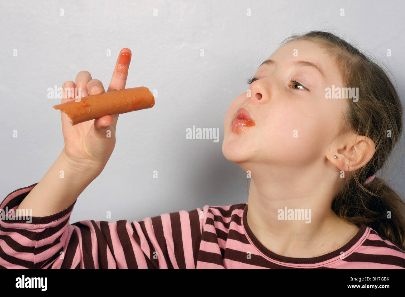 Young girl enjoying a Frankfurter sausage Stock Photo